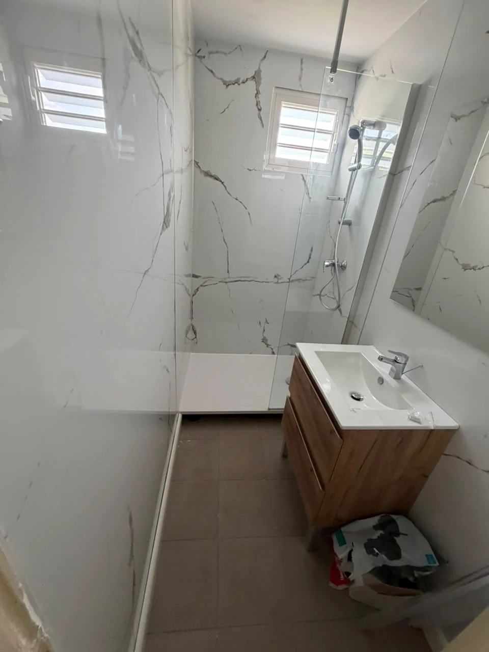 Salle de bain rénovée à Paradis avec panneaux muraux et douche vitrée